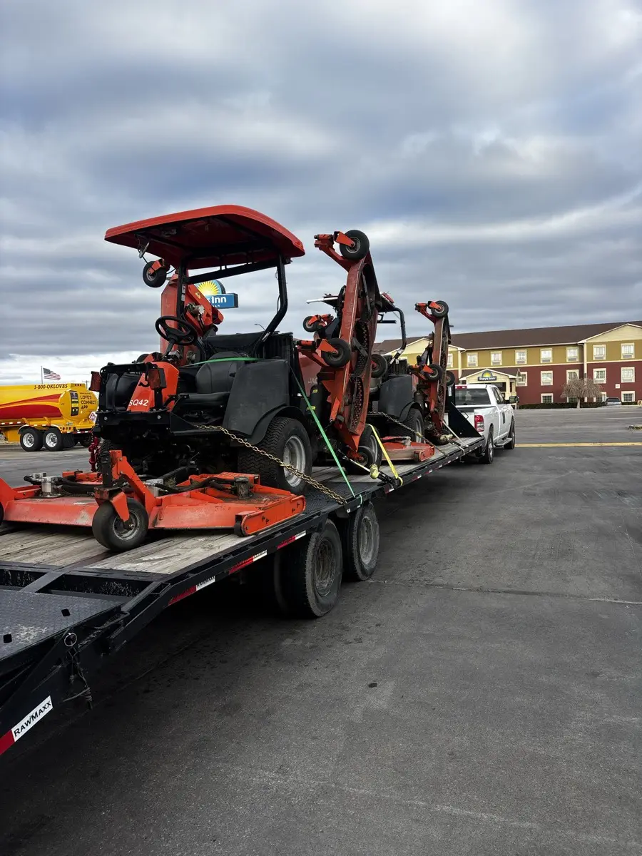 Orange commercial mowers strapped to the trailer